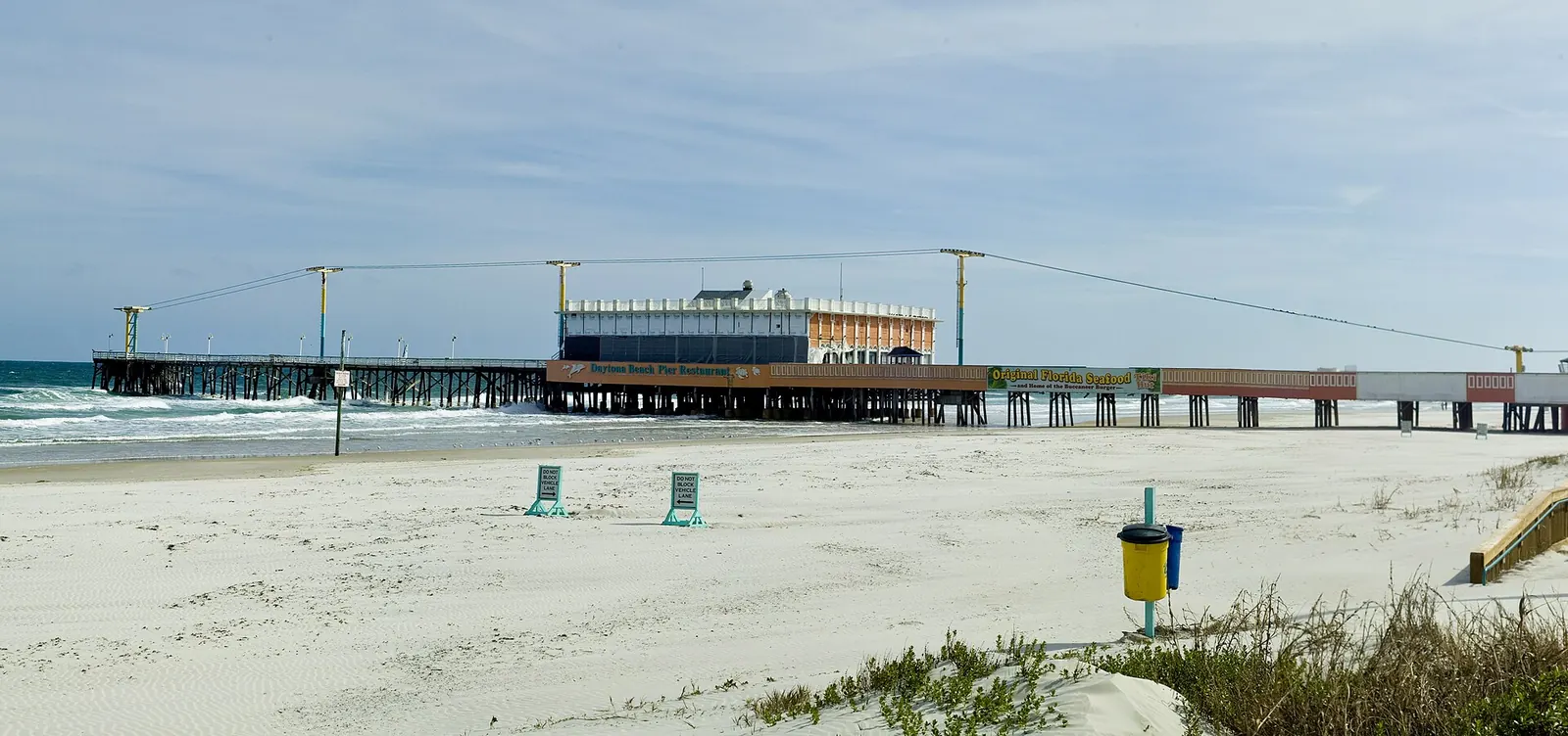 Daytona Beach pier and restaurant stretching into the surf beyond an empty sandy beach