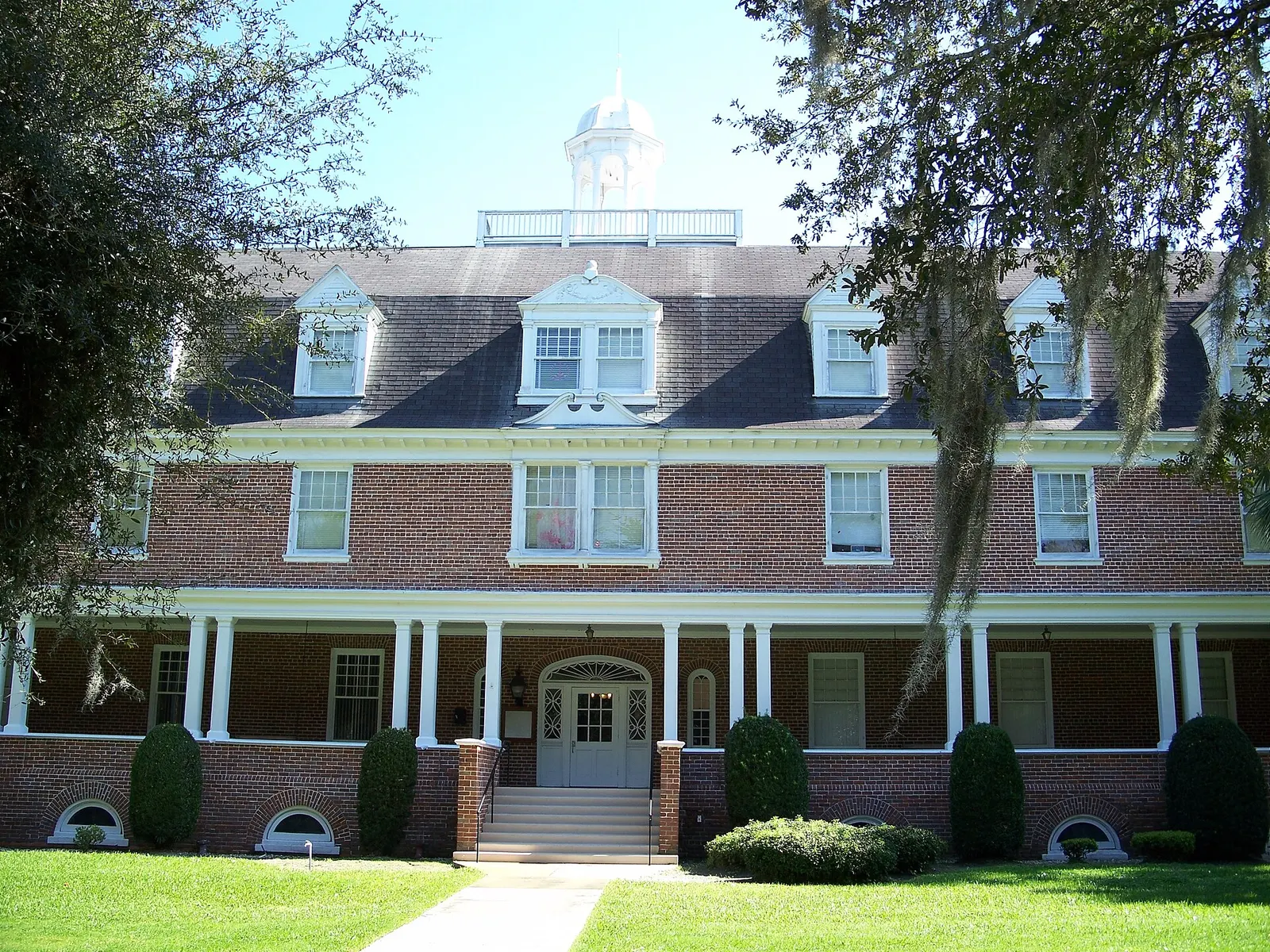 Three-storey red-brick Chaudoin Hall with a white columned porch and cupola on the Stetson University campus