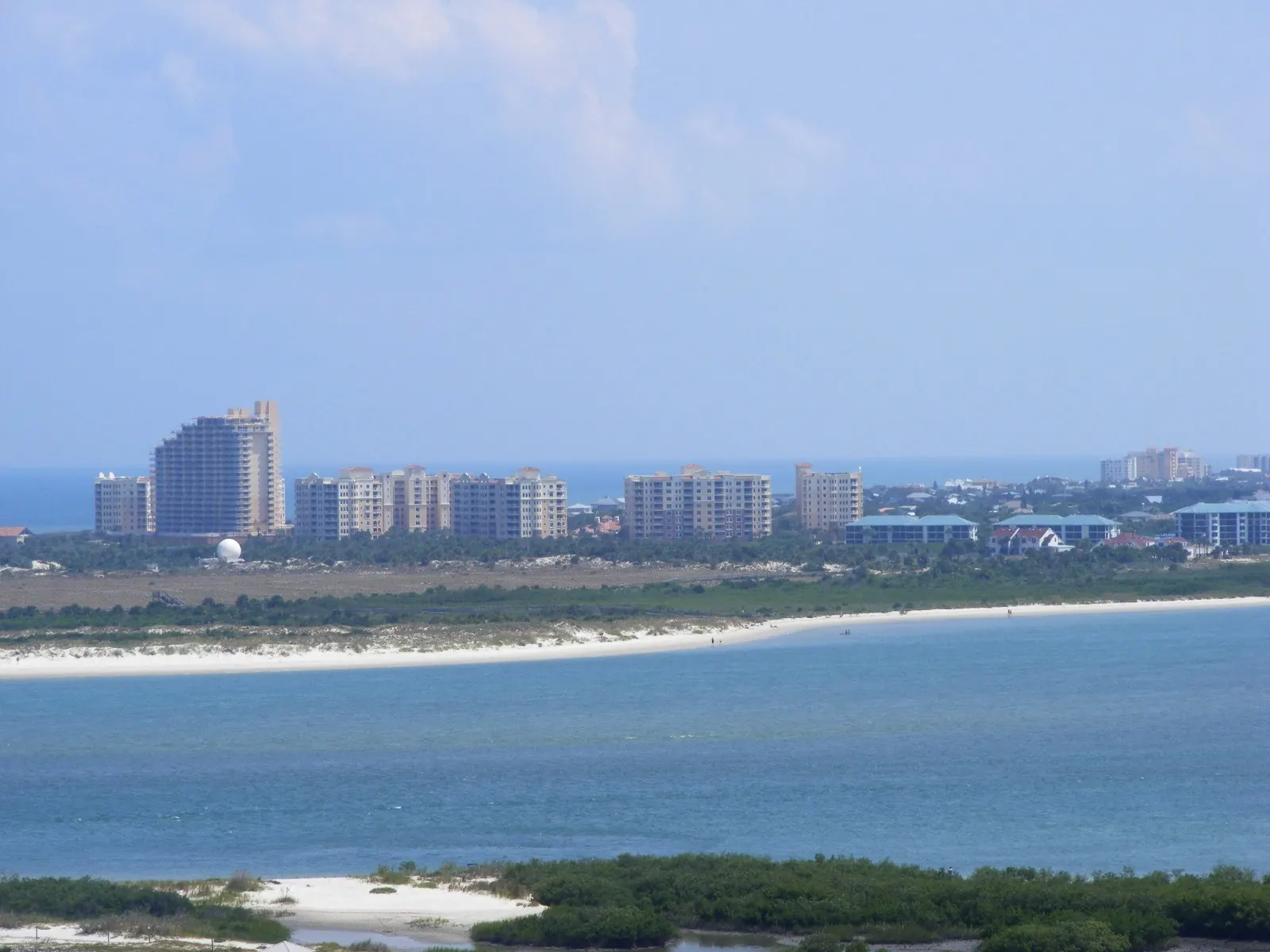 Condo towers along the New Smyrna Beach shore seen across the blue water of the inlet