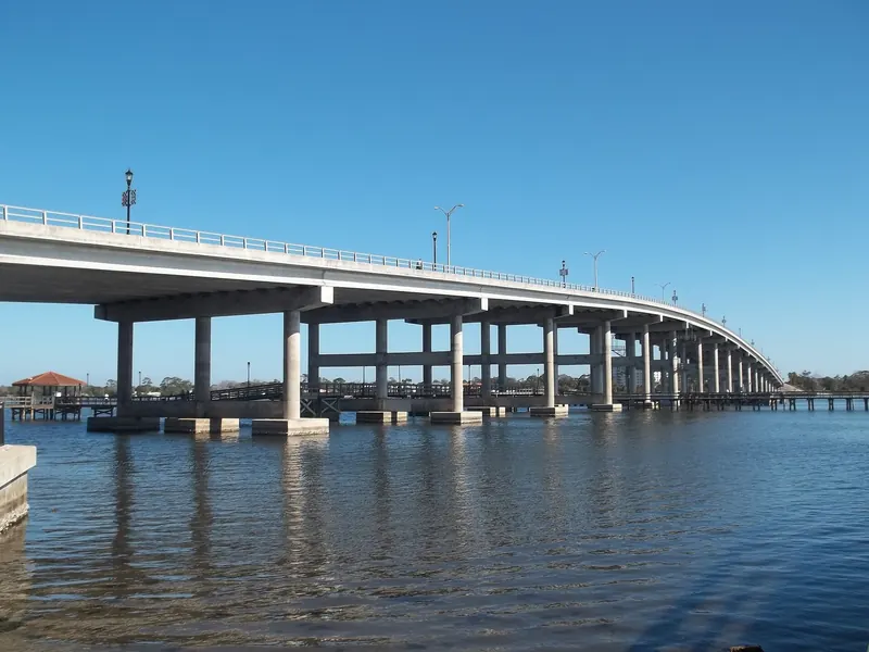 Concrete Granada Bridge spanning the Halifax River with a pier and red-roofed pavilion nearby