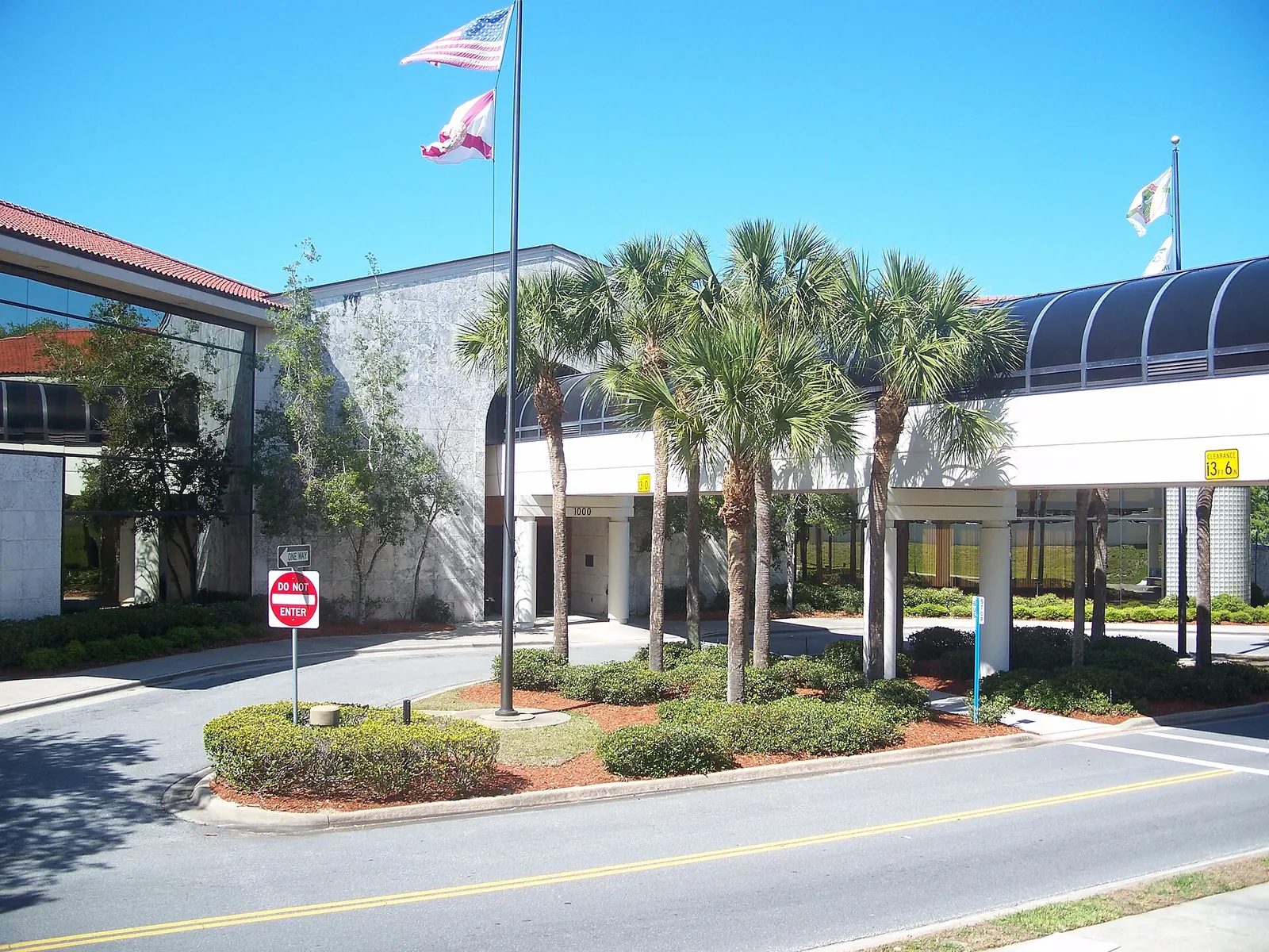 Port Orange City Hall entrance with palm trees, flags and a covered walkway